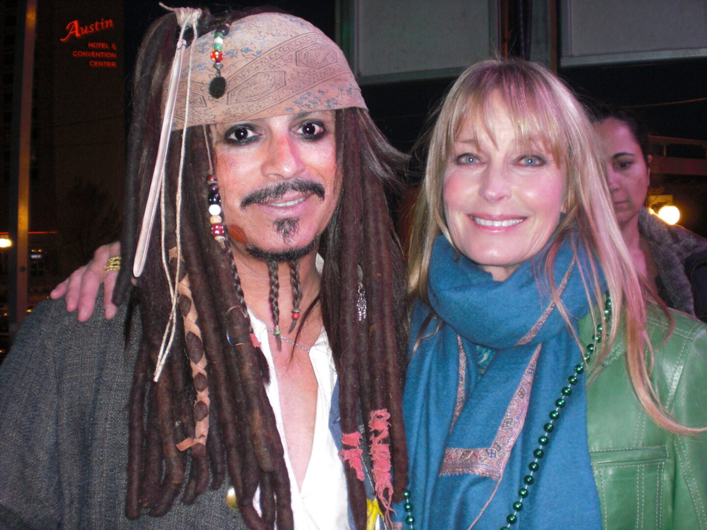 A person wearing a scarf standing close to someone n wearing a costume from Pirates of the Caribbean