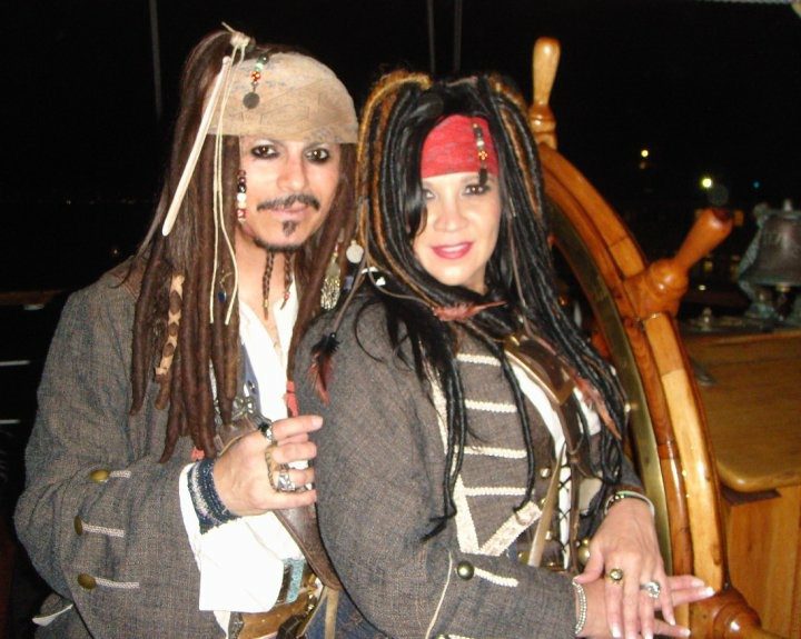 Two people standing beside each other wearing costumes from Pirates of the Caribbean